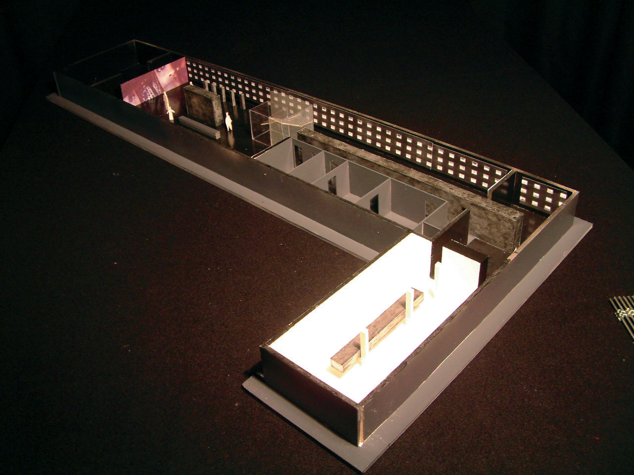 Kontrasten mellom den mørke utstillingen og det hvite rommet framheves som et godt formalt grep. (Illustrasjon: Arkitekten.)