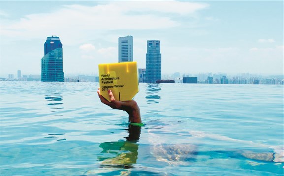 Det håndfaste bevis på at A-lab mottok WAF-prisen for Statoil-bygget i kategorien for beste kontorbygg i 2013. Bildet er tatt i bassenget på taket av Marina Bay Sands. 
Mannen under vann er arkitekt og assosiert partner i A-lab, Erik Olav Marstein. Foto: Odd Klev, arkitekt og partner i A-lab