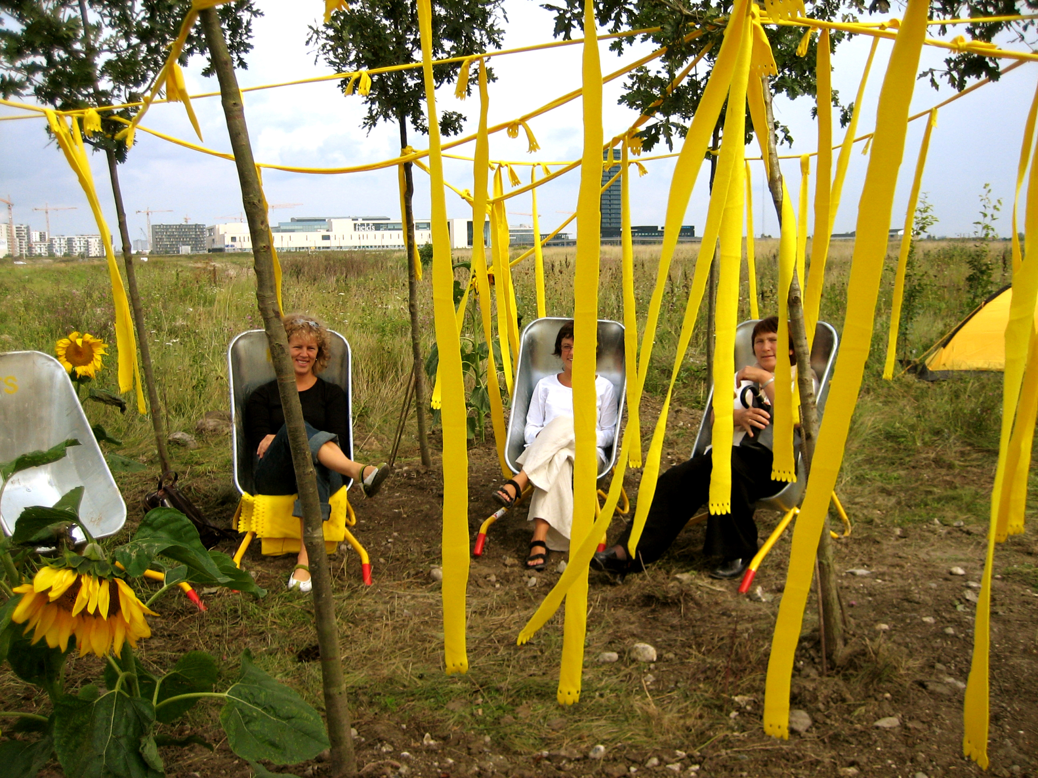 Inspirert av Cormiers dogmer formet landskapsarkitektene en liten utestue, en intim samlingsplass, avgrenset av flagrende gule tøyremser og møblert med for mange en overraskelse, trillebårer med gule tepper som hvilestoler. Et forsiktig avgrenset rom i rommet.