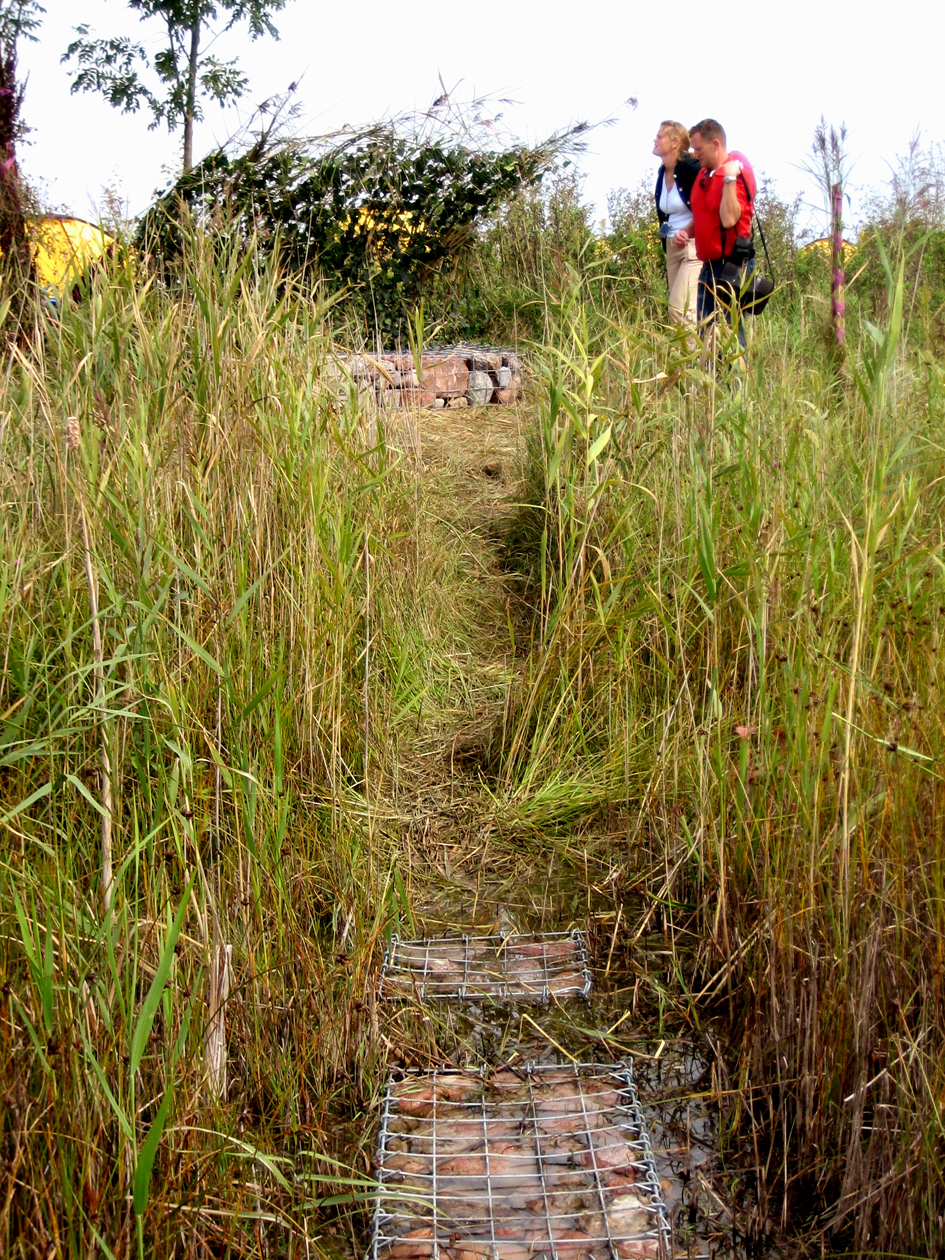 I en symbiose mellom Amagers landskap, Stanges dogmer og mesterklassens erfaringer ble det med enkle grep laget flere små landskapsrom. En møteplass, en klopp, en sti, en benk og le mot den danske vinden. Back to basic både i funksjon og materialbruk. Helt tro mot dogmene har de ikke vært. Nettingen fant de neppe der. Hvis ikke det er rester av gjerder. Fotos: Ingrid Haukeland. 
Inspirert av Cormiers dogmer formet landskapsarkitektene en liten utestue, en intim samlingsplass, avgrenset av flagrende gule tøyremser og møblert med for mange en overraskelse, trillebårer med gule tepper som hvilestoler. Et forsiktig avgrenset rom i rommet.