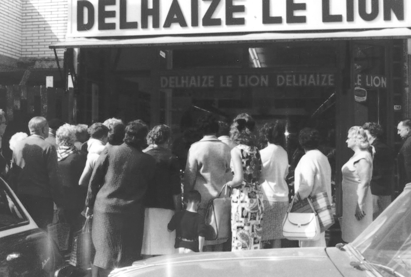 Lang kø av nysgjerrige foran Delhaize, Belgias første supermarked. Lang kø av nysgjerrige foran Delhaize, Belgias første supermarked.