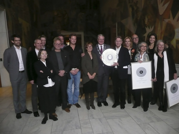 Ordfører Fabian Stang flankert av de lykkelige vinnerne Elin Grimstvedt, GASA og Trygve Berg, Omsorgsbygg. Lengst til
høyre arkitekt Henriette Salvesen, div.A som fikk hederlig omtale for Kastellet skole. Femte mann fra venstre er Jørn Narud i Narud Stokke Wiig som fikk hederlig omtale for den nyere delen av Bjørnholt videregående skole. Foto: Magdalena Eckersberg