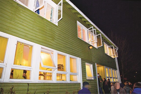 Beboere og ansatte er på vei inn fra kulda etter julefest for gutta på transittmottaket denne kvelden.  