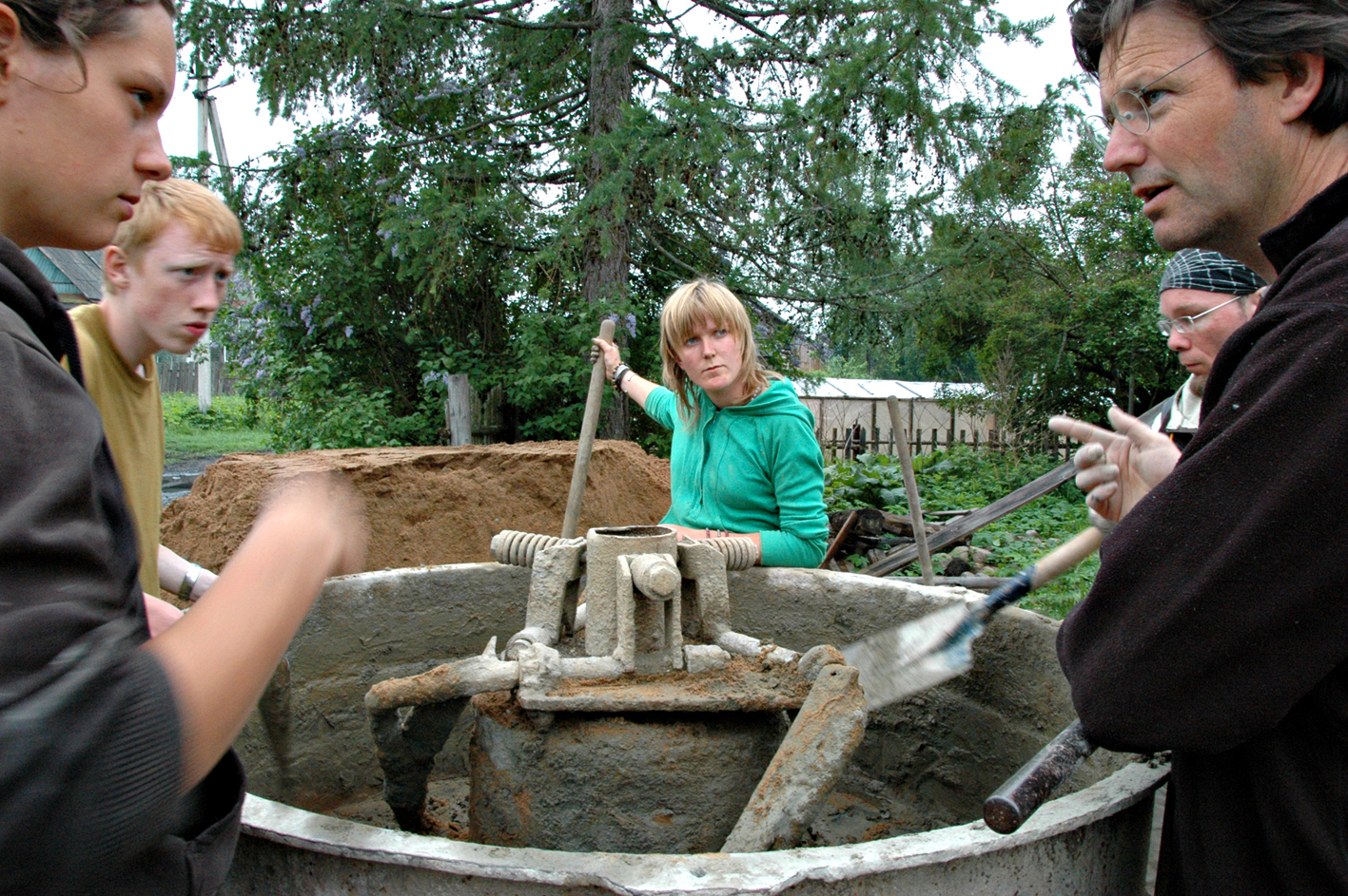 Arbeidsgjeng. Leira har størkna i blandemaskina, og Russland har bitt seg fast i sjela til unge og litt eldre på byggetur til Rysjkova; frå venstre Romina Potzka, Anders Malte Gustavson, Ine Kristiansen, ein namnlaus russar og Rolf Jacobsen.